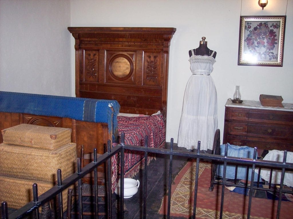 Interior of Sanchez Adobe in Woodside with period clothing and furniture from 1800s