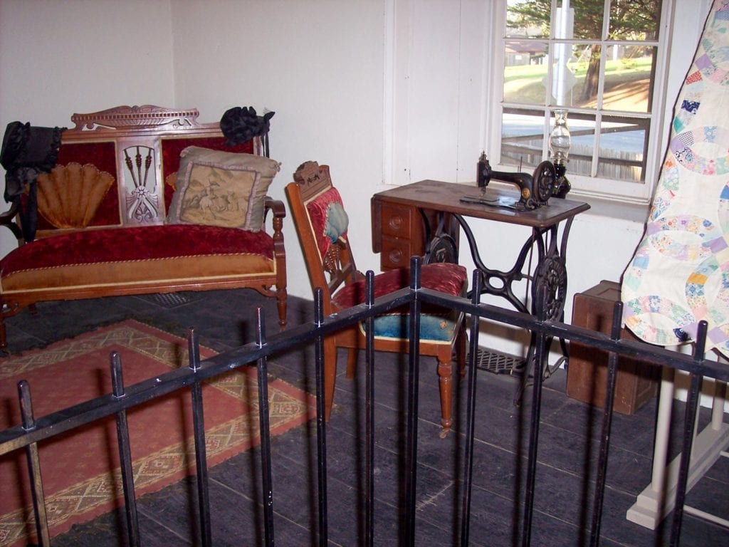 Interior of Sanchez Adobe in Woodside with period clothing and furniture from 1800s