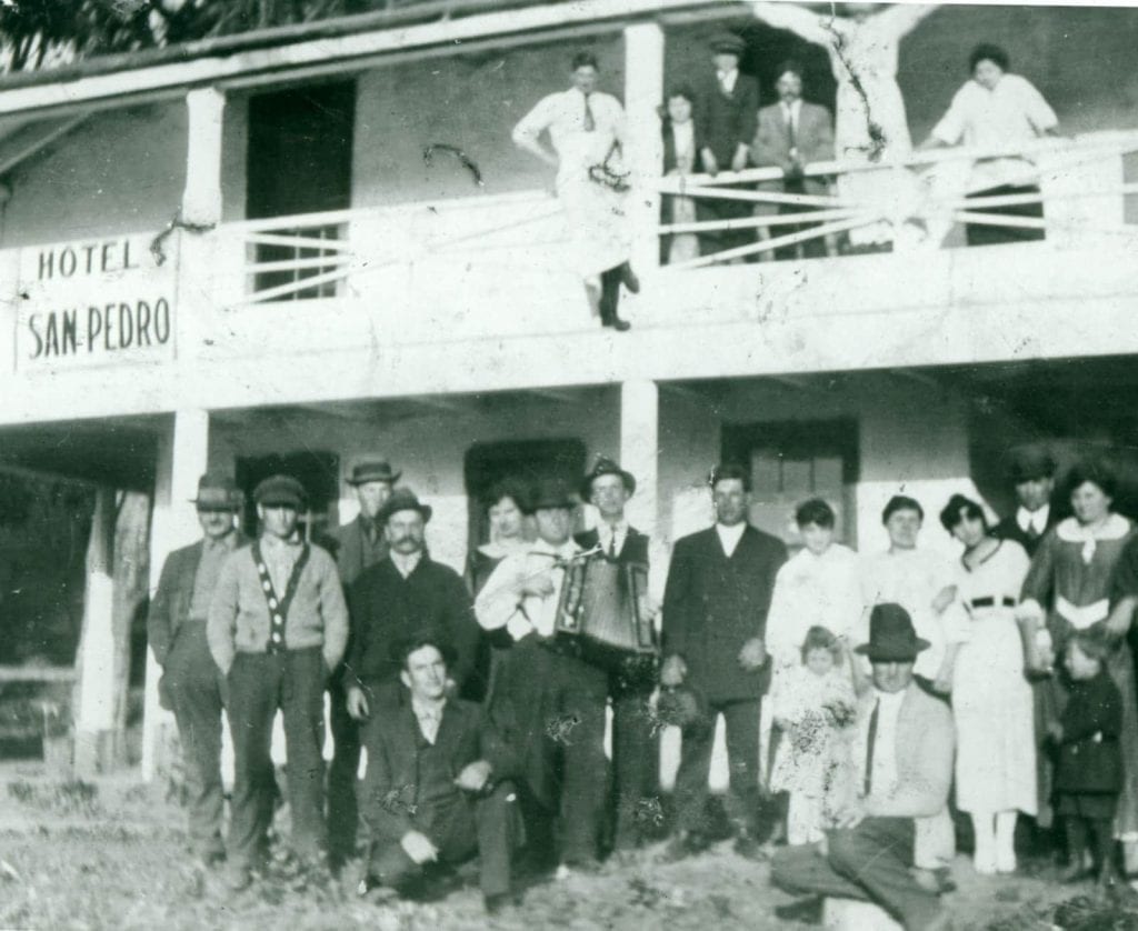 Archival photo of a group of people posing in front of Hotel San Pedro current site of Sanchez Adobe