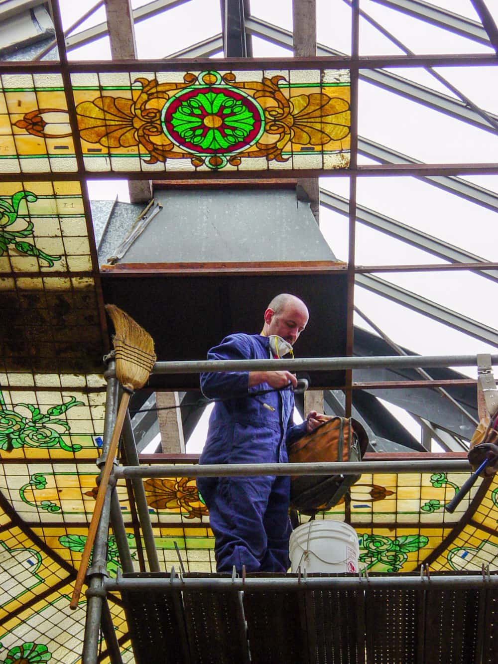 Workers on scaffolding install a section of stained glass in the dome of the San Mateo County Courtroom A