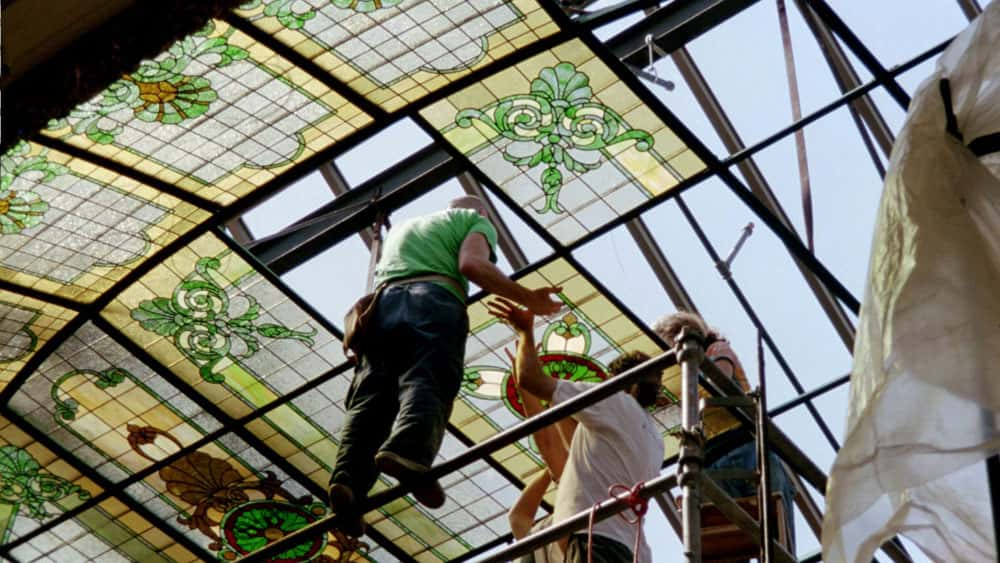 Workers on scaffolding install a section of stained glass in the dome of the San Mateo County Courtroom A