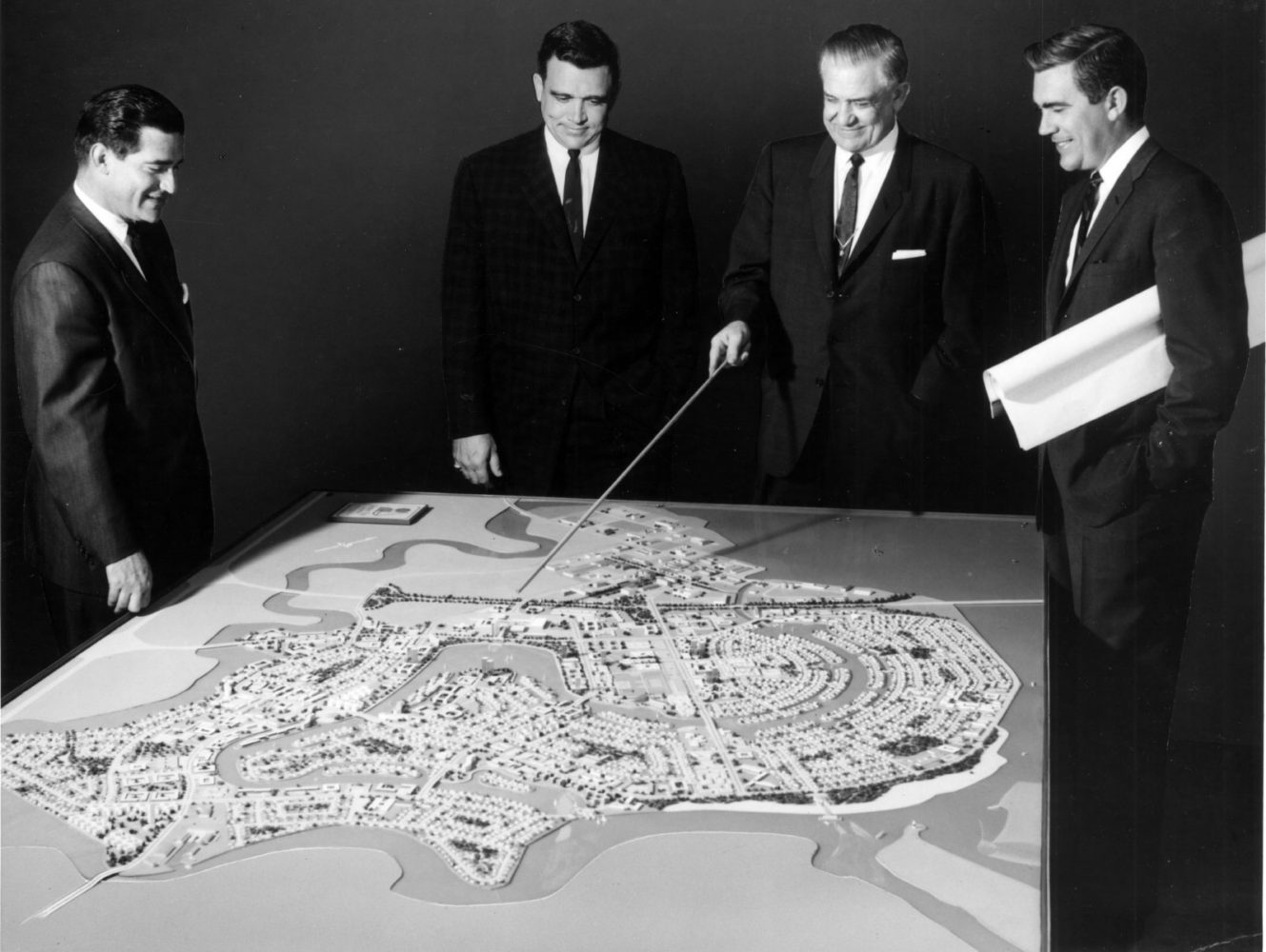 The Foster family surveying a model of planned community Foster City