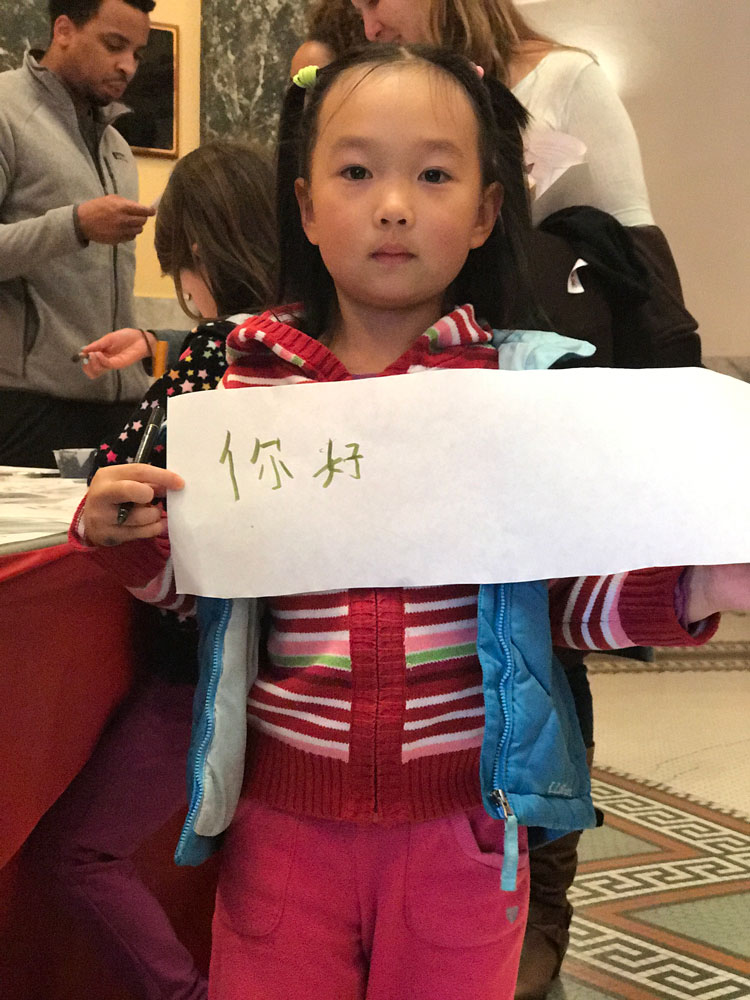 A young girl holds up chinese calligraphy at Lunar New Year celebration at the San Mateo County History Museum