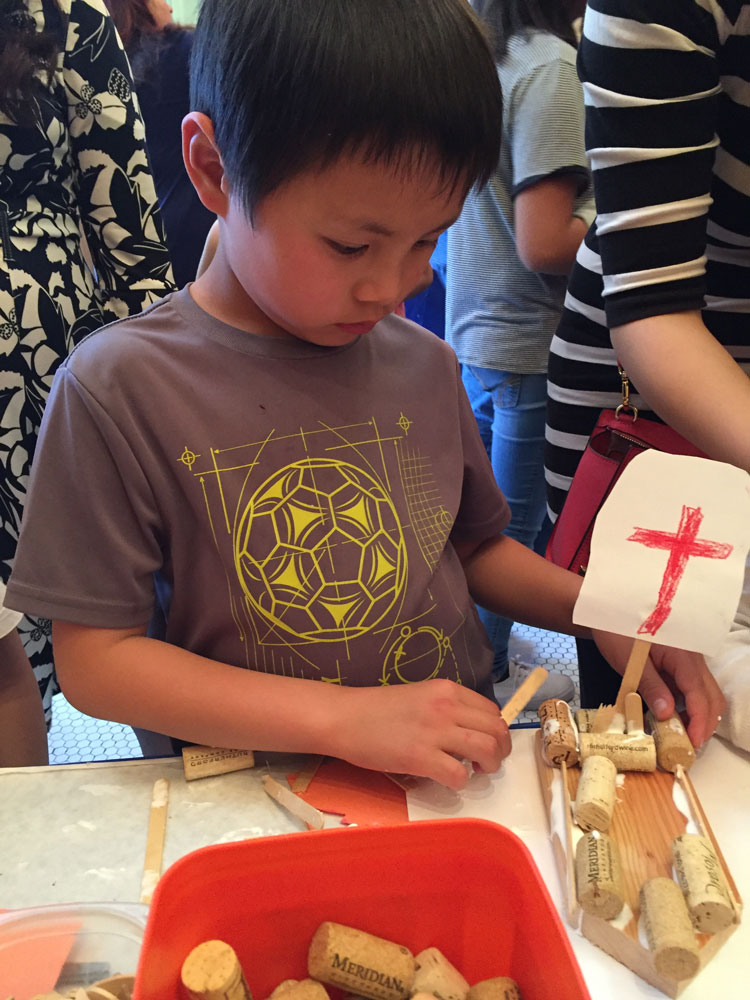 A young boy makes a boat craft at Maritime Day at the San Mateo History Museum