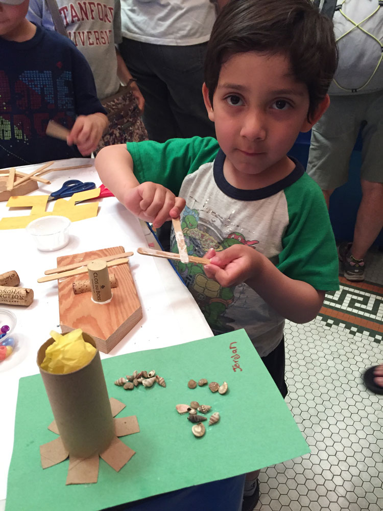 A young boy makes a boat craft at Maritime Day at the San Mateo History Museum