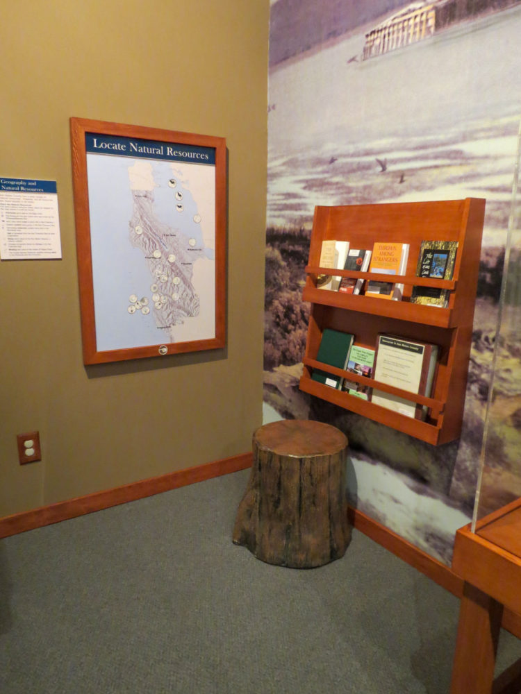 Exhibit display of maps and books at Natures Bounty at the San Mateo County History Museum