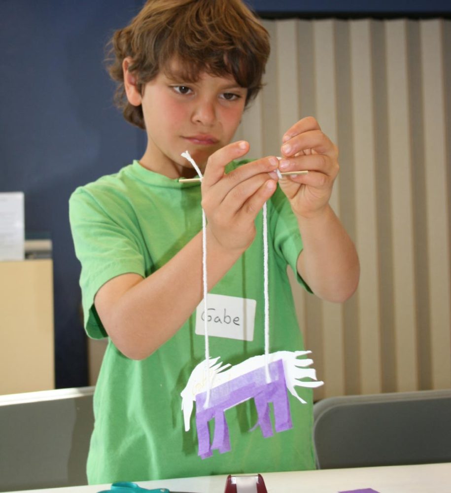 A young student creates an Italian marionette in the People from Many Places school program at the San Mateo County History Museum