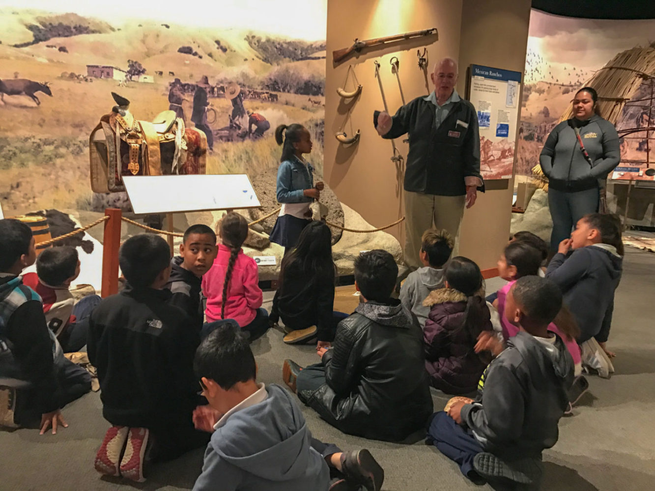 Students listen to a staff member at Providing Plenty school program at the San Mateo County History Museum