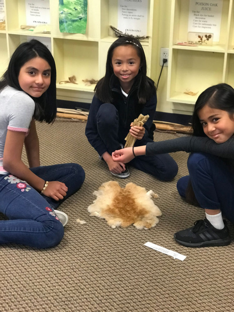 Students throw traditional sticks at Providing Plenty school program at the San Mateo County History Museum