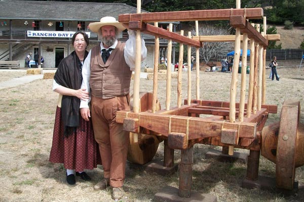 Sanchez Adobe in the background with docents dressed in early California period costume