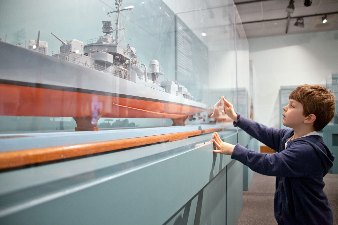 A young boy looking at Ships of the World exhibit at the San Mateo County History Museum