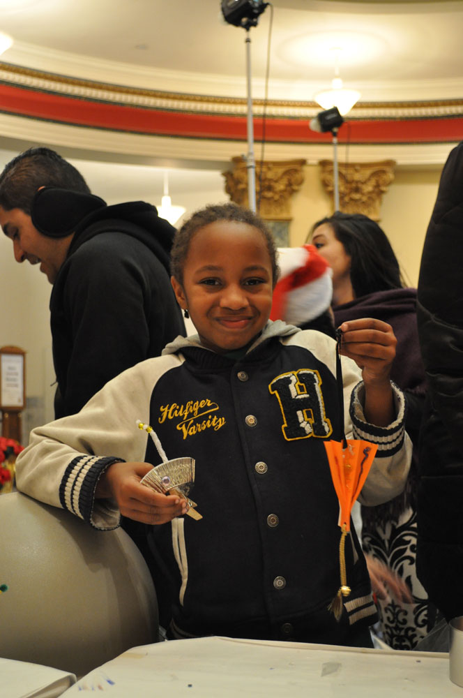 Young boy holding a handcrafted ornament at the San Mateo History museum