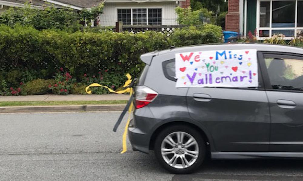 A car with a sign that says We miss you Vallemar during COVID 19