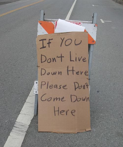 Street sign that says If you don't live down here please dont come down here