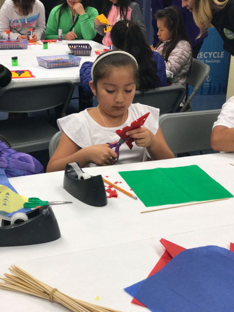 A young student cuts a paper craft on the People from Many Places school program at the San Mateo County History Museum