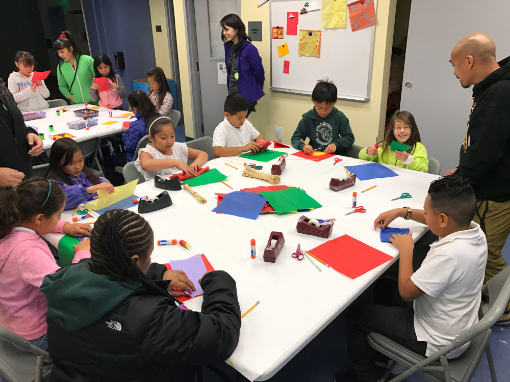 Student create a paper craft on the People from Many Places school program at the San Mateo County History Museum