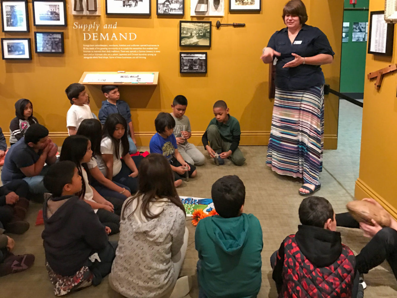 Students listen to a docent on the People from Many Places school program at the San Mateo County History Museum