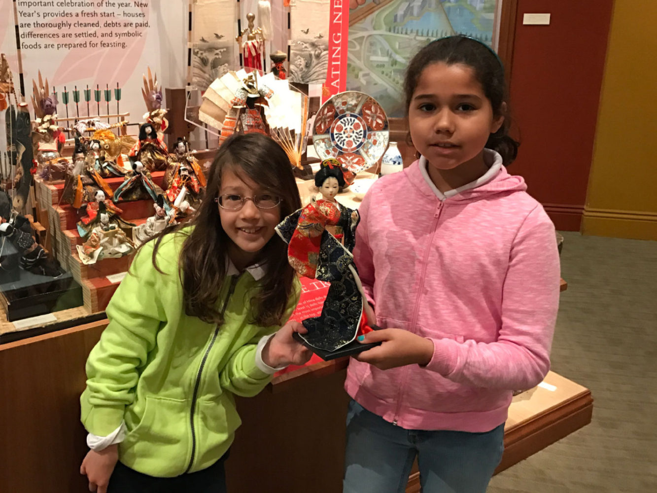 Students hold a doll at the People from Many Places school program at the San Mateo County History Museum