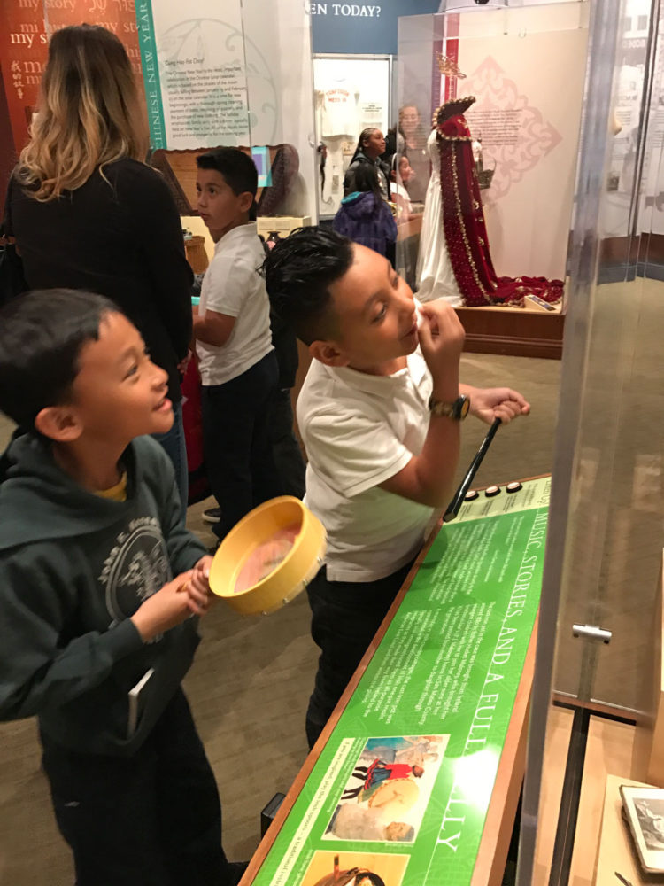 Students view an exhibit display the People from Many Places school program at the San Mateo County History Museum