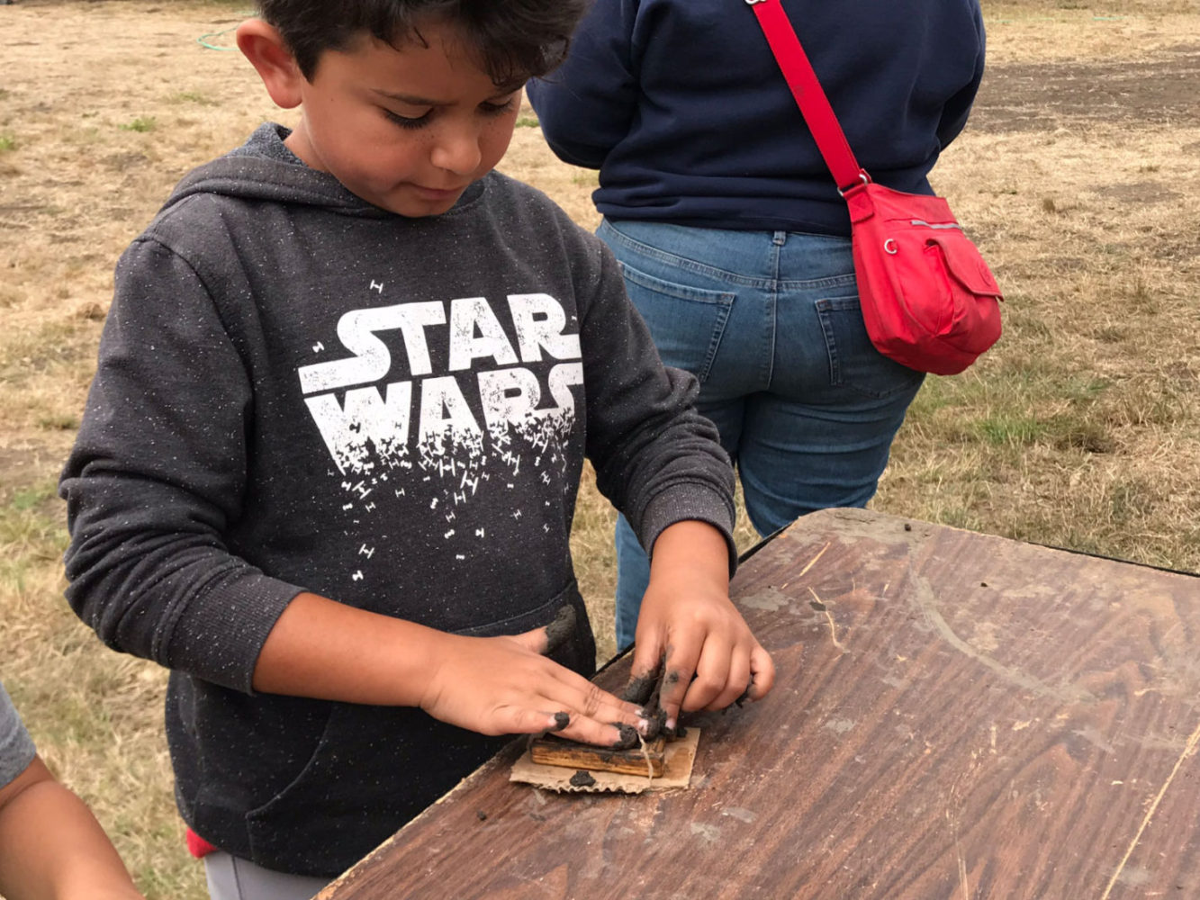 A young boy works on a craft at Rancho Fiesta Day at Sanchez Adobe