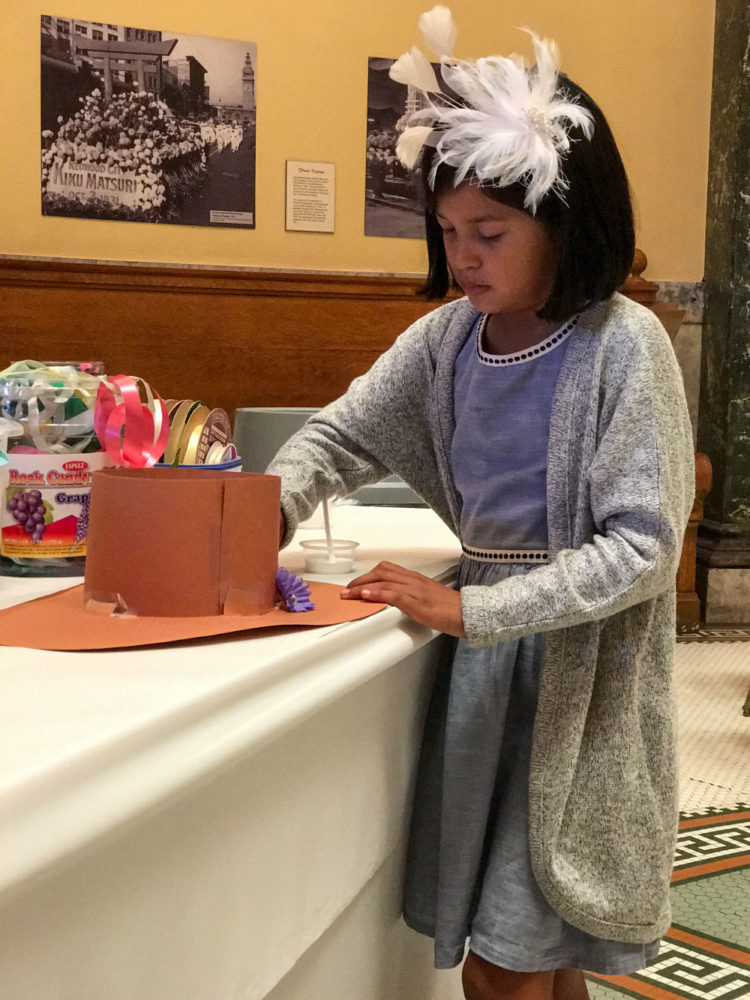 A girl makes a hat craft at Victorian Days at the San Mateo County History Museum