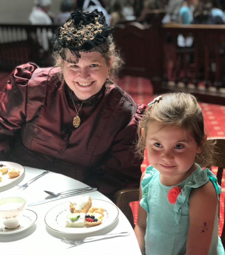 A woman and young girl enjoy afternoon tea at Victorian dress at San Mateo County History Museum