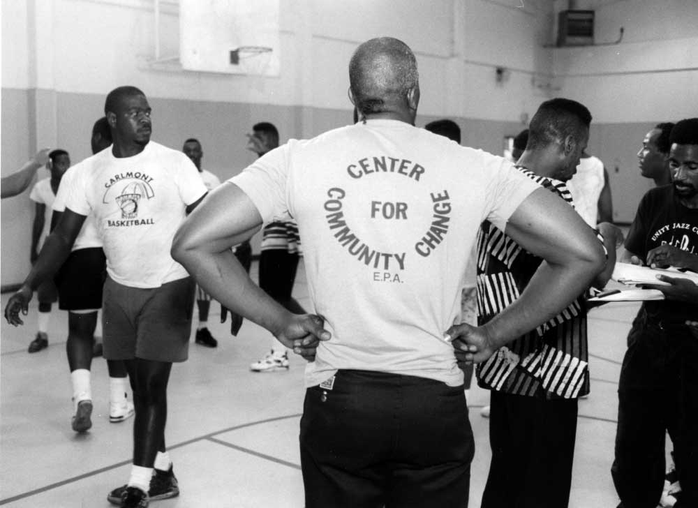 Midnight basketball try outs at Bell Street Gym with a man wearing a tshirt that says Center for Cummunity Change EPA