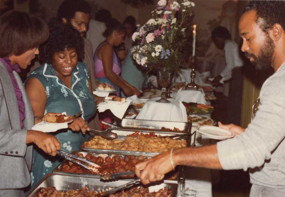 An African American community gathering potluck