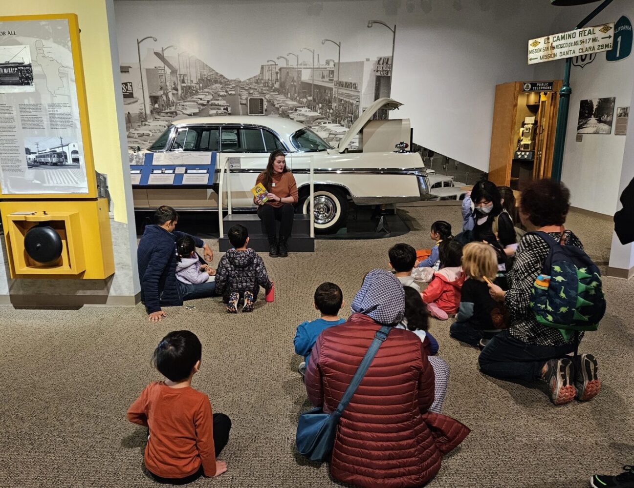 Staff member reading a story to a group of families