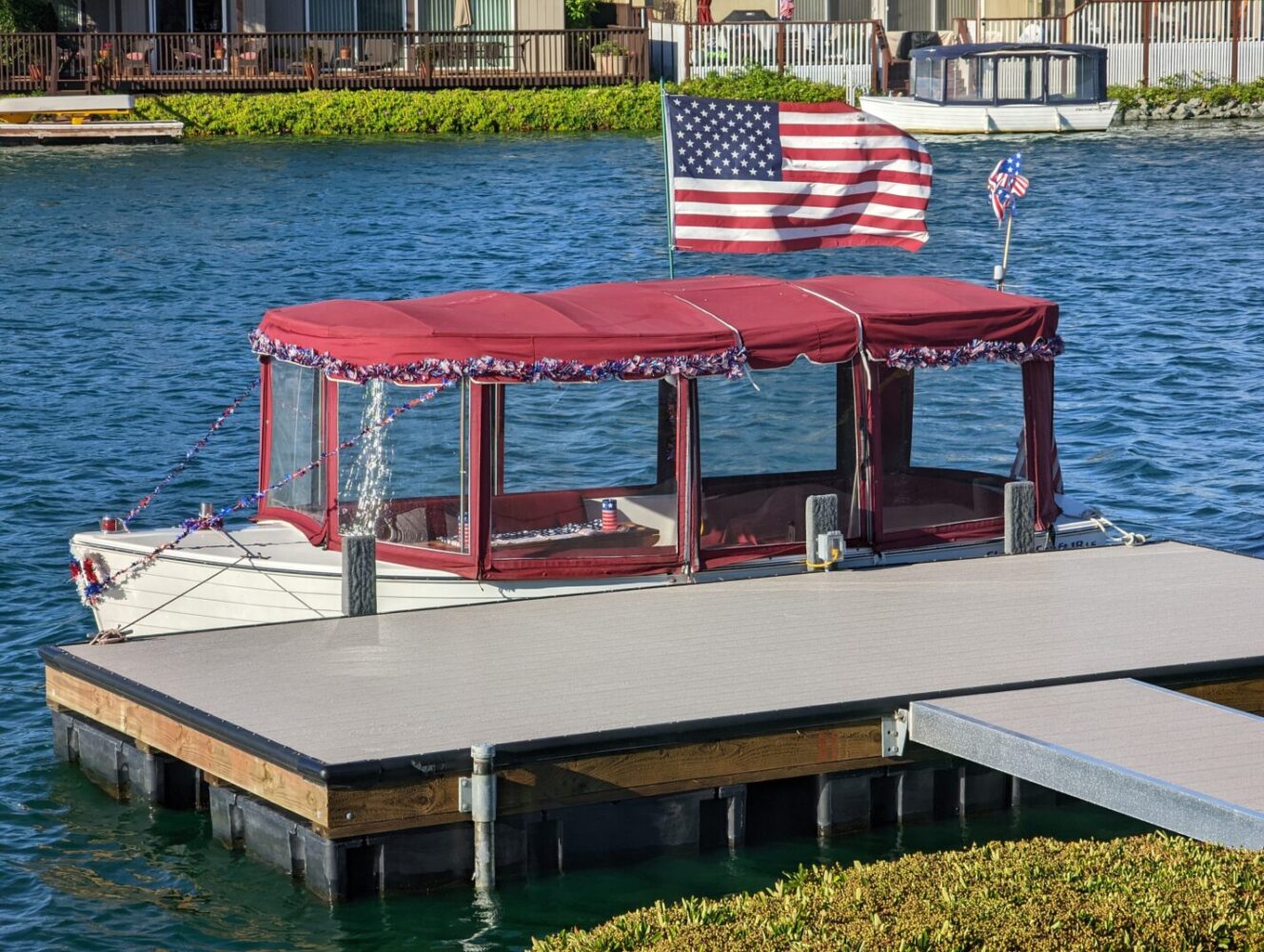 Boat with red roof and American flag docked at in Foster City