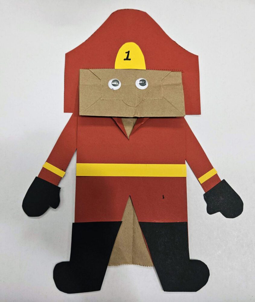 Firefighter puppet dressed in a red uniform and helmet