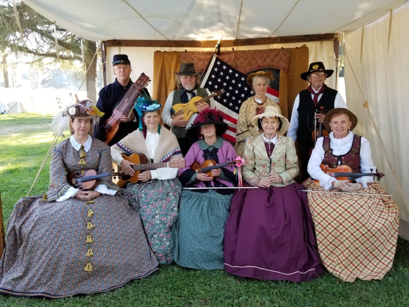 Musicians in Victorian outfits holding string instruments